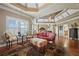 Spacious main bedroom with tray ceilings, recessed lighting, seating area, and hardwood floors at 2088 Skybrooke Ct, Hoschton, GA 30548