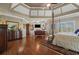Spacious main bedroom with a tray ceiling, hardwood floors, and elegant furnishings at 2088 Skybrooke Ct, Hoschton, GA 30548