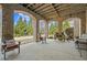 Covered patio with brick arches, ceiling, and comfortable seating area with views of the manicured yard at 2088 Skybrooke Ct, Hoschton, GA 30548