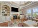Sitting area with built-in shelving, a fireplace, and large windows at 2088 Skybrooke Ct, Hoschton, GA 30548