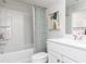 Well-lit bathroom with a shower-tub combo, toilet, sink with vanity, and framed modern art at 3034 Cambridge Ml, Acworth, GA 30102
