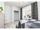 Well-lit bedroom with a large window, patterned curtains, hardwood floors, and closet at 3034 Cambridge Ml, Acworth, GA 30102