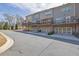 Rear exterior showcasing multi-level townhomes with balconies overlooking a spacious backyard and parking at 318 Lantana Ln, Woodstock, GA 30188