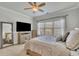 Bright bedroom featuring a ceiling fan, a large window, and a modern television at 318 Lantana Ln, Woodstock, GA 30188