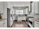 Bright kitchen features stainless steel appliances, white cabinetry, granite countertops, and a window for natural light at 318 Lantana Ln, Woodstock, GA 30188