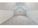 An unfinished attic space with sloped ceilings, carpet, and a window at 3412 Hard Creek Ln, Buford, GA 30519