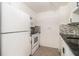 Galley-style kitchen with white cabinets and appliances plus a modern backsplash and black countertops at 375 Ralph Mcgill Ne Blvd # 804, Atlanta, GA 30312