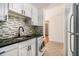 A kitchen with white cabinets, sleek black countertops, modern appliances including a washing machine, and stylish tile backsplash at 375 Ralph Mcgill Ne Blvd # 804, Atlanta, GA 30312