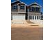 Modern townhome exterior with attached garages and neutral color palette against a blue sky at 11555 Kimberly Way # 19, Hampton, GA 30228