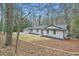 Charming ranch-style house with a well-maintained lawn and freshly painted exterior nestled in a lush wooded setting at 1555 Sunnybrook Farm Rd, Atlanta, GA 30350