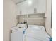 Practical laundry room with a washing machine and dryer with overhead cabinets for storage at 1555 Sunnybrook Farm Rd, Atlanta, GA 30350