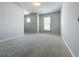 Spacious bedroom with a view featuring neutral walls, trim, and plush carpeting at 2560 Quarterdeck Dr, Cumming, GA 30041