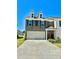 Beautiful two-story townhome with a three car garage, landscaped yard, and neutral brick facade at 2560 Quarterdeck Dr, Cumming, GA 30041