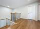 Hallway with wood floors and a wooden railing on the stairs at 2560 Quarterdeck Dr, Cumming, GA 30041