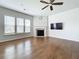 Bright living room featuring a fireplace, ceiling fan, large windows, and hardwood flooring at 2560 Quarterdeck Dr, Cumming, GA 30041