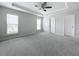 Spacious main bedroom featuring tray ceilings, neutral walls, carpet flooring and two large bright windows at 2560 Quarterdeck Dr, Cumming, GA 30041