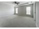 Spacious main bedroom featuring a tray ceiling, ceiling fan, neutral walls and plush carpeting at 2560 Quarterdeck Dr, Cumming, GA 30041