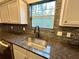 Close-up of kitchen sink featuring granite countertops and tiled backsplash at 6159 Sable Fox Dr, Riverdale, GA 30296