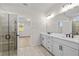 Bright bathroom with double vanity, white cabinets, and walk-in shower with a glass door at 1692 Juniper Berry Way, Loganville, GA 30052