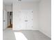 Empty room with neutral carpet, white trim, and a pair of double doors at 1692 Juniper Berry Way, Loganville, GA 30052