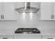 Close-up of a modern kitchen with white countertops and an elegant stainless steel range hood at 1692 Juniper Berry Way, Loganville, GA 30052