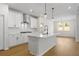 Open-concept kitchen with white cabinets, a central island, and stainless steel appliances, blending style and functionality at 1692 Juniper Berry Way, Loganville, GA 30052