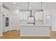 Well-lit kitchen with white cabinets, stainless steel appliances, and an island for food preparation at 1692 Juniper Berry Way, Loganville, GA 30052