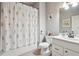 Well-lit bathroom featuring a floral shower curtain, modern fixtures, and a clean, inviting space at 2126 Roberts View Trl, Buford, GA 30519