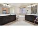 Bright bathroom with dual vanity sinks, dark cabinetry, a soaking tub, and natural light from a window at 2126 Roberts View Trl, Buford, GA 30519