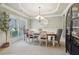 Formal dining room with modern chandelier, wainscoting, and gray accent walls at 2126 Roberts View Trl, Buford, GA 30519