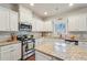 Bright, modern kitchen featuring granite countertops, stainless steel appliances, and ample cabinet space at 2126 Roberts View Trl, Buford, GA 30519