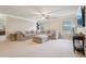 Cozy living room with a sectional sofa, ceiling fan, neutral walls, and plush carpet at 2126 Roberts View Trl, Buford, GA 30519