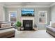 Bright living room with fireplace, large windows, and stylish furniture creating a cozy atmosphere at 2126 Roberts View Trl, Buford, GA 30519