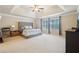 Spacious primary bedroom with tray ceiling, neutral walls, plush carpet, and lots of natural light at 2126 Roberts View Trl, Buford, GA 30519