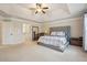 Primary bedroom featuring a large bed, tray ceilings, neutral walls, and plenty of space at 2126 Roberts View Trl, Buford, GA 30519