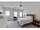 Bright bedroom with neutral carpet features a modern ceiling fan and natural light from two windows at 1175 Glenridge Pl, Atlanta, GA 30342