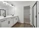 A bathroom with a dual vanity, modern lighting, and a glass shower enclosure at 5384 Heron Bay Blvd, Locust Grove, GA 30248