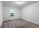 A brightly lit bedroom featuring neutral carpet and a large window at 5384 Heron Bay Blvd, Locust Grove, GA 30248