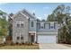 Charming two-story home with a brick and gray facade and a two-car garage, exuding curb appeal at 5384 Heron Bay Blvd, Locust Grove, GA 30248