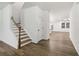 Hallway with hardwood floors, staircase, and open access to other rooms enhancing the flow of the house at 5384 Heron Bay Blvd, Locust Grove, GA 30248