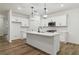 Bright, modern kitchen with a large island, white cabinets, and hardwood floors at 5384 Heron Bay Blvd, Locust Grove, GA 30248