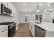 Modern kitchen with stainless steel appliances, large island, and hardwood floors at 5384 Heron Bay Blvd, Locust Grove, GA 30248