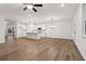 Open-concept living room with a kitchen, hardwood floors, and ample natural light at 5384 Heron Bay Blvd, Locust Grove, GA 30248