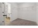 Spacious walk-in closet featuring metal shelving, neutral carpeting, and white trim and doors at 5384 Heron Bay Blvd, Locust Grove, GA 30248