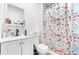 Cozy bathroom features a floral shower curtain, modern sink and vanity, and mirrored medicine cabinet at 6219 Wurtenburg Ct, Stone Mountain, GA 30087
