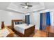 Bedroom with tray ceiling, modern fan, and hardwood floors at 6219 Wurtenburg Ct, Stone Mountain, GA 30087