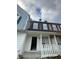 Two-story townhome with neutral colors, well-kept facade and open front porch at 498 Prince Of Wales, Stone Mountain, GA 30083