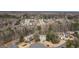 Aerial view showcasing a residential neighborhood with tree-lined streets, several homes, and mature trees at 7880 Brands Hatch Blvd, Cumming, GA 30040