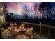 Outdoor living on a deck with comfortable seating area illuminated by string lights with a view of the natural landscape at 7880 Brands Hatch Blvd, Cumming, GA 30040