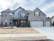 Stately gray brick home with manicured landscaping, three car garage and inviting curb appeal at 3988 Two Bridge Drive, Buford, GA 30519